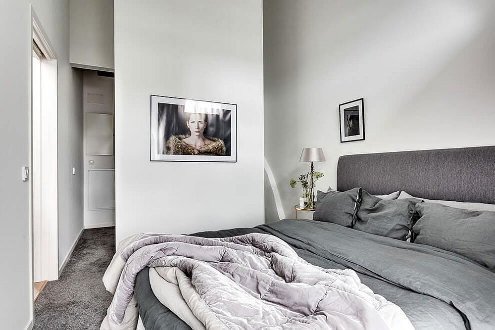 Bedroom in white and gray with small bathroom next to it