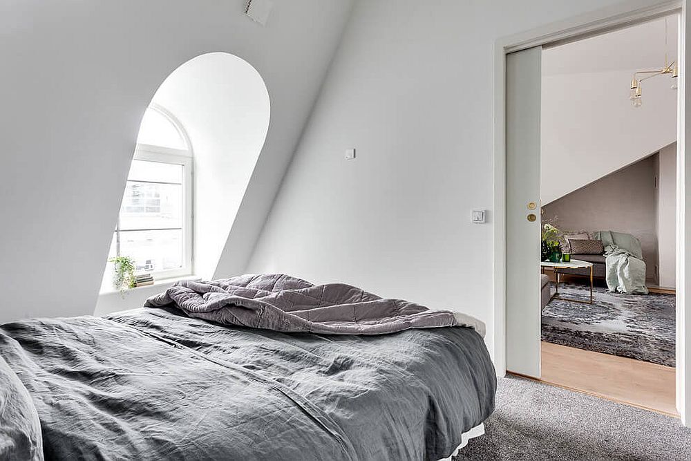 Bedroom of the small attic apartment in white and gray