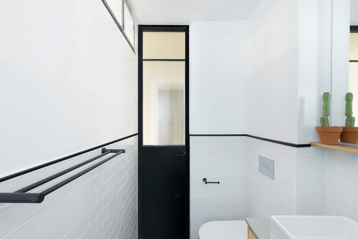 Black door offers contrast in the white modern bathroom