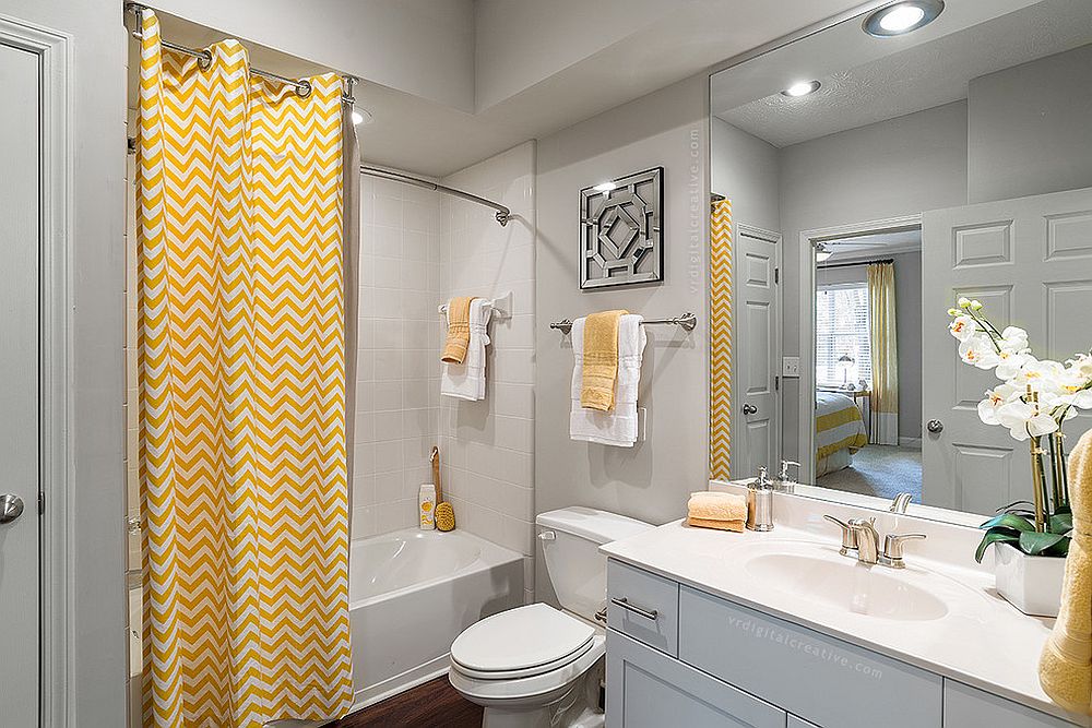 Curtain with chevron stripes brings yellow to the modern gray bathroom