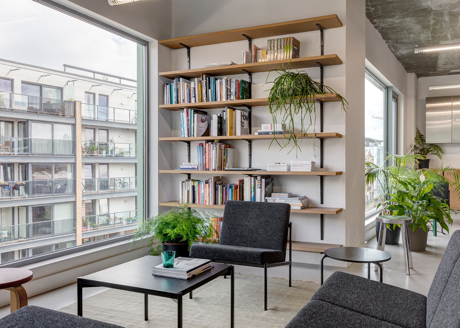 The multi-use lounge area of Dezeen's office includes Ilmari Tapiovaara's Kiki sofa and armchairs and Aino Aalto's 606 Side Table. Image via Dezeen.