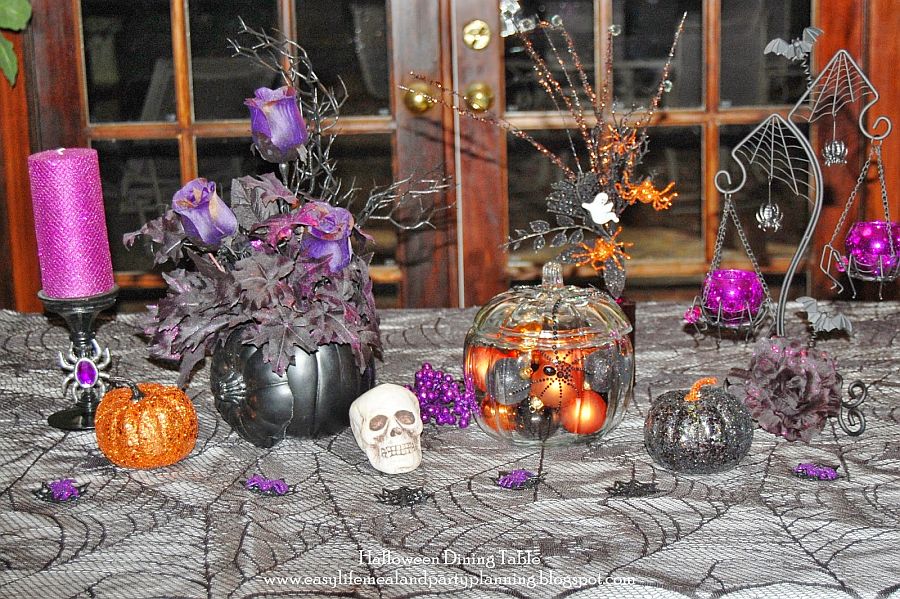 Exquisita y divertida decoración de mesa de Halloween con calabazas negras y centro de mesa floral