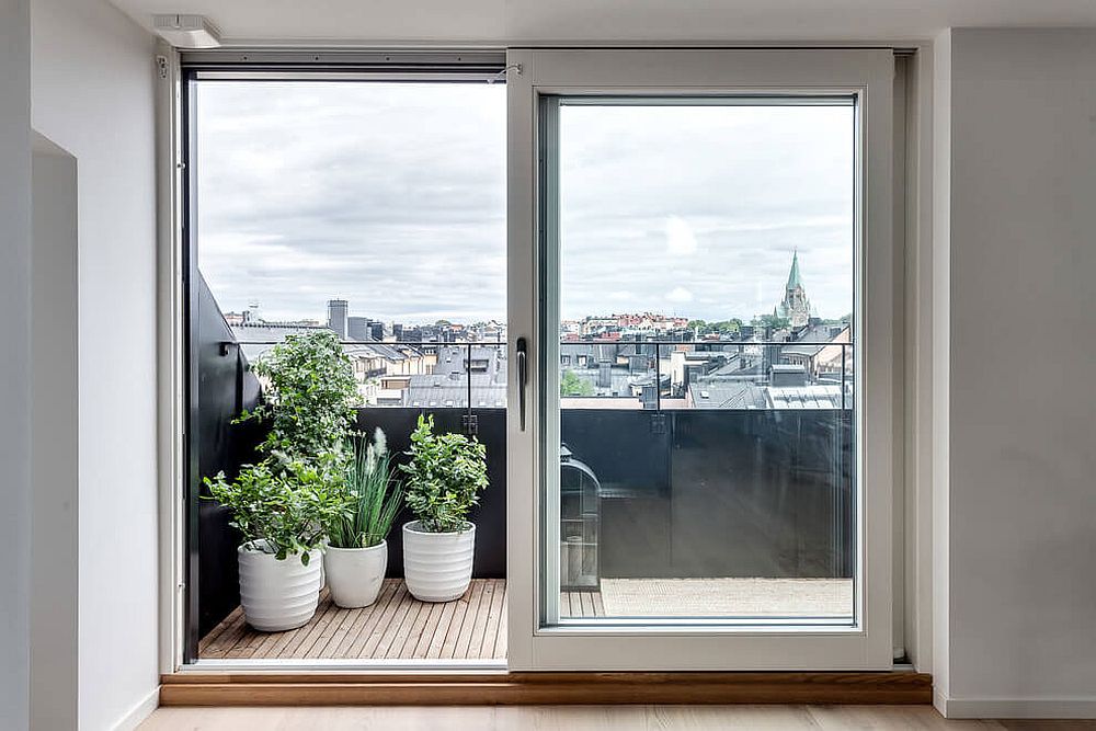 Framed. sliding glass doors connect the attic apartment with the tiny balcony