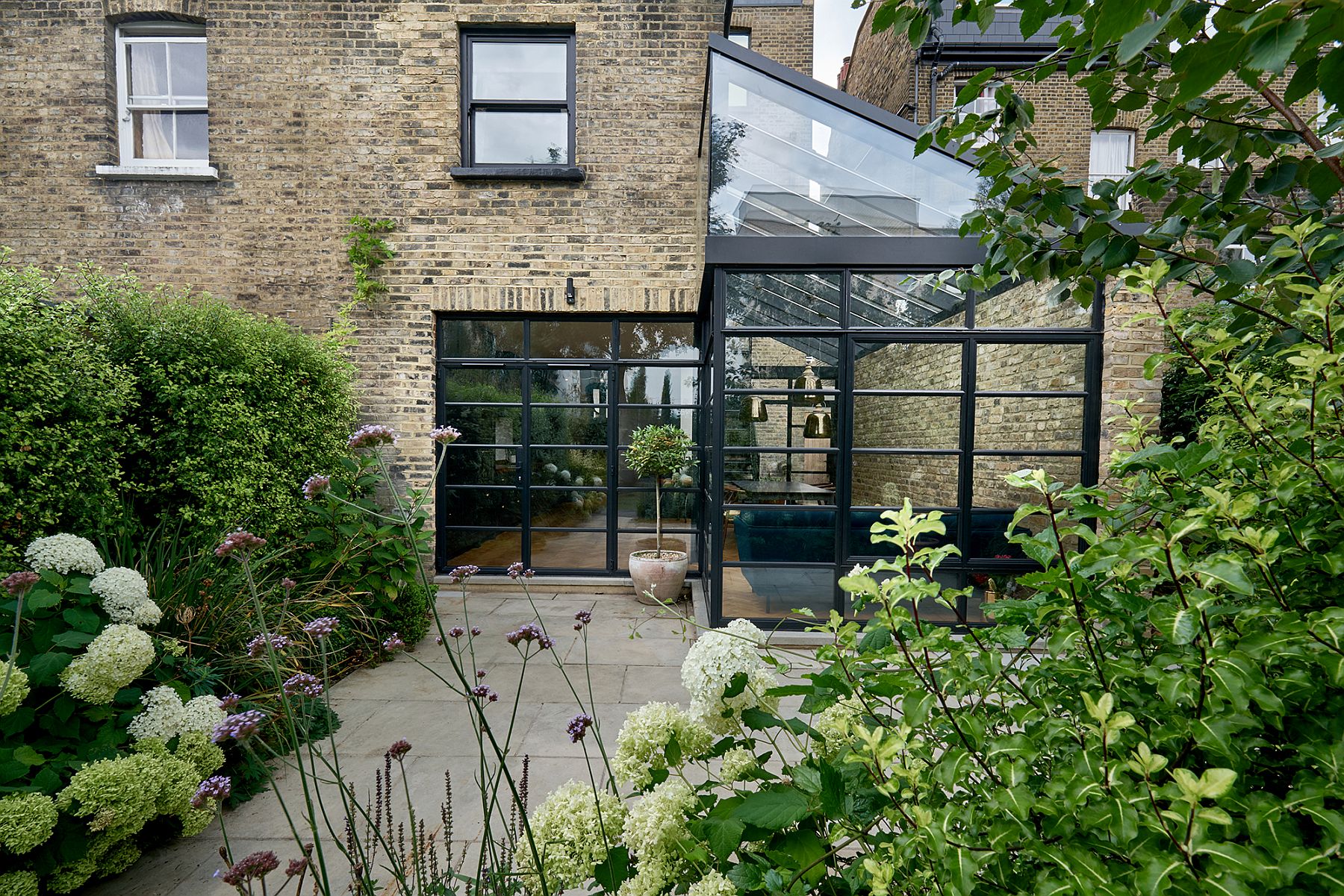 Garden outside becomes a part of the new dining room and kitchen thanks to the glassy extension