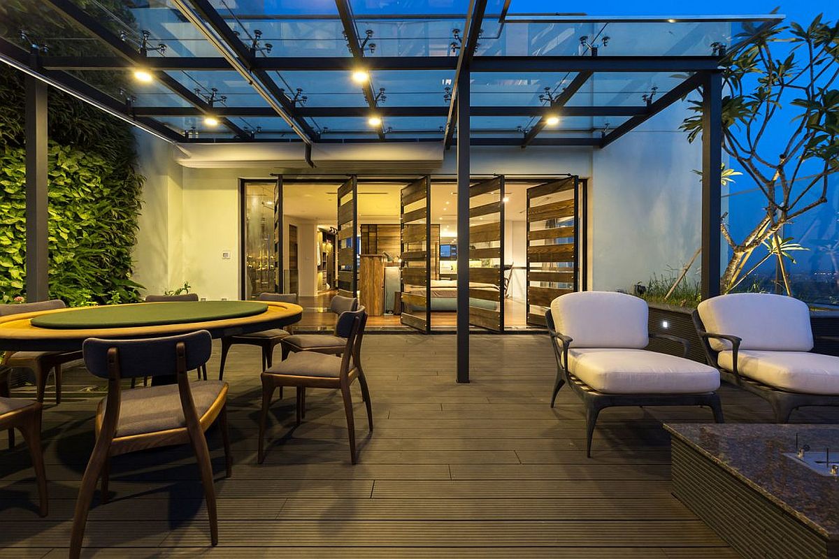 Glass and steel pergola offers shade to the outdoor dining and lounge