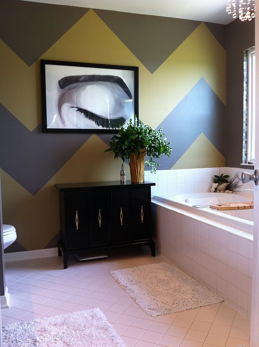 Gray and yellow chevron stripes create a a stylish accent wall in the bathroom [Design: Home Girl Décor]