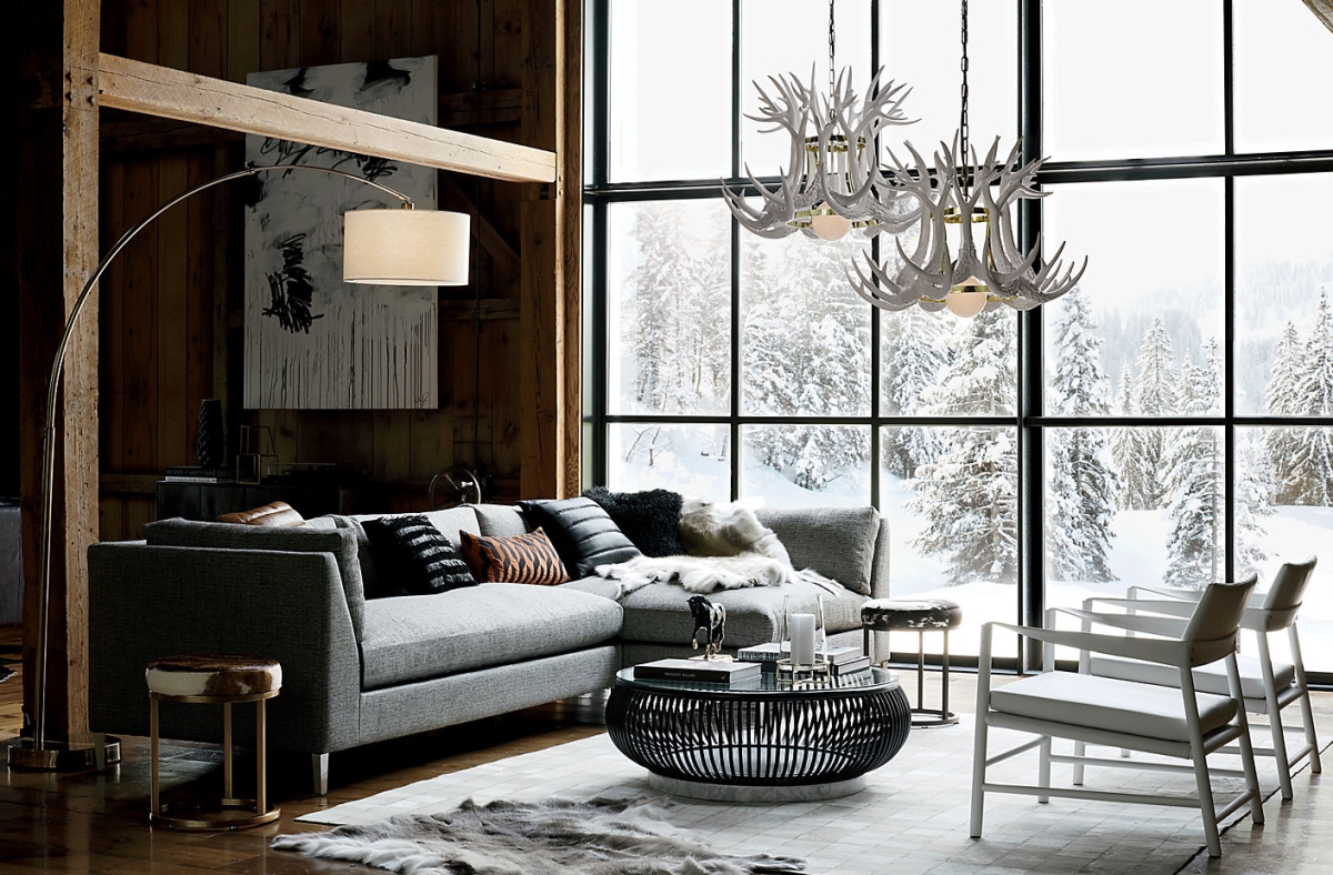 Grey sofa and wooden walls in a chalet styled by CB2