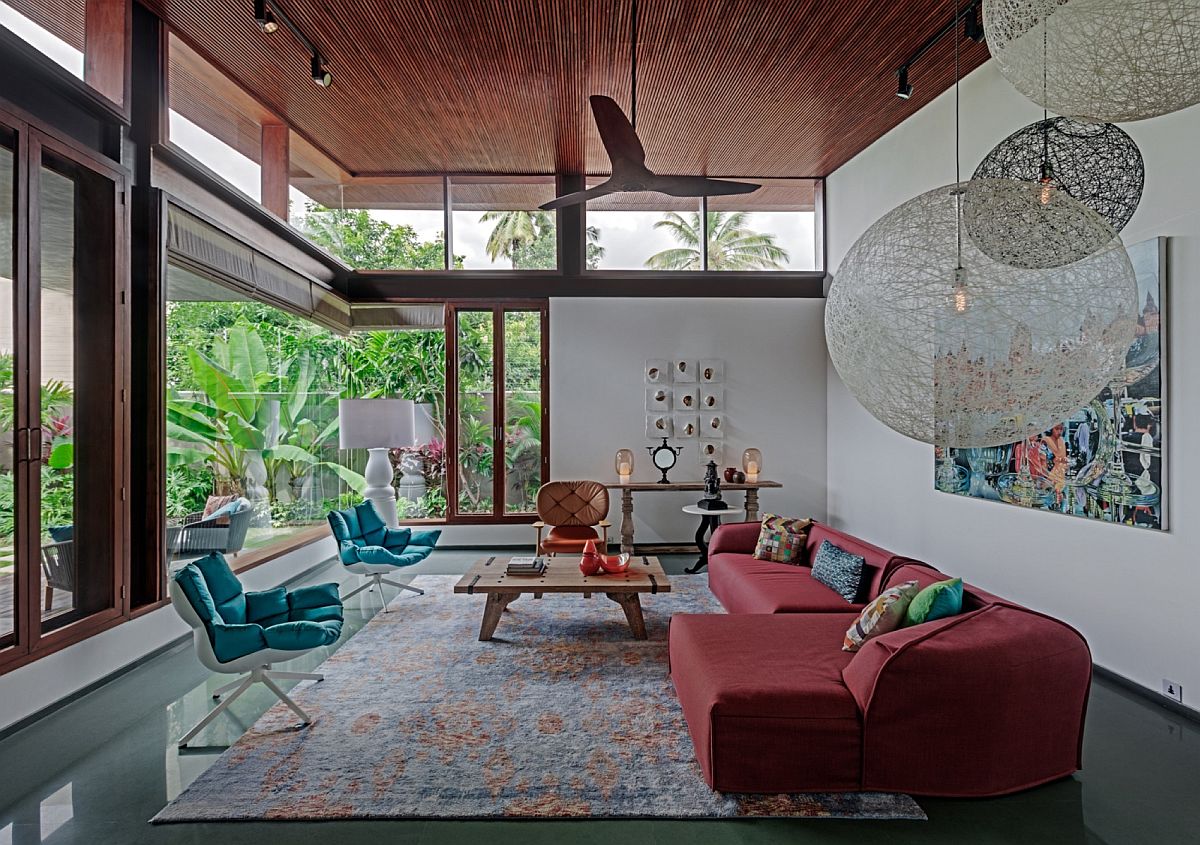 Living room with glass walls, colorful furniture and large pendants from Moooi