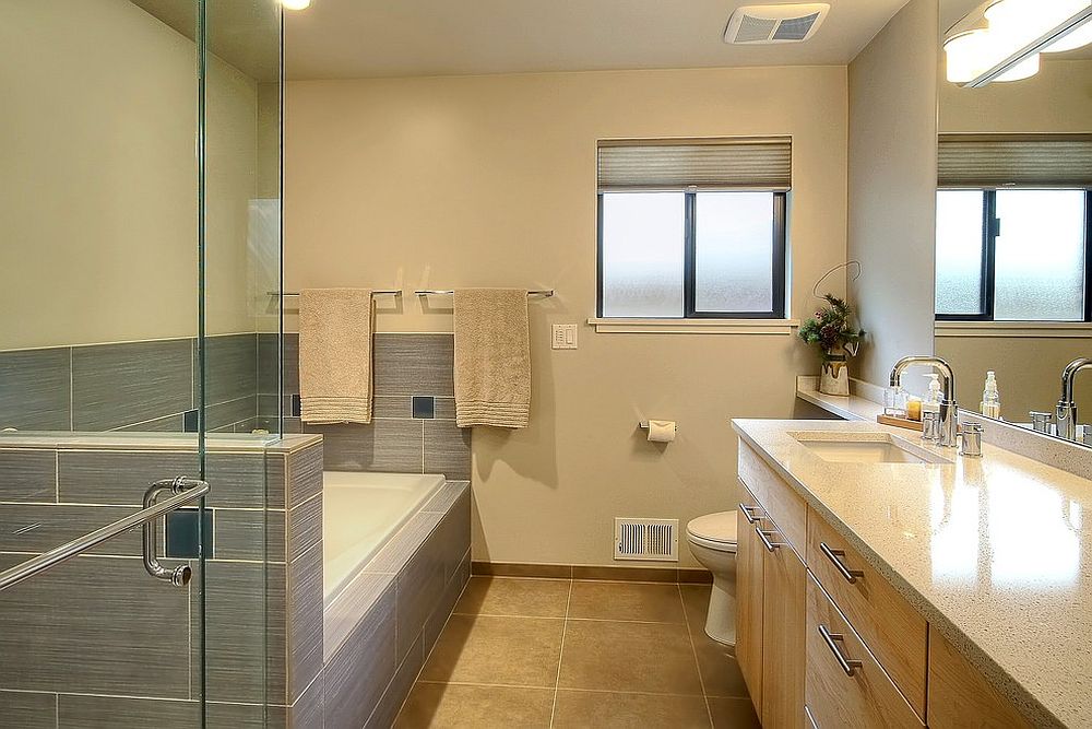 Maple cabinetry adds to the yellow and gray color scheme of the bathroom