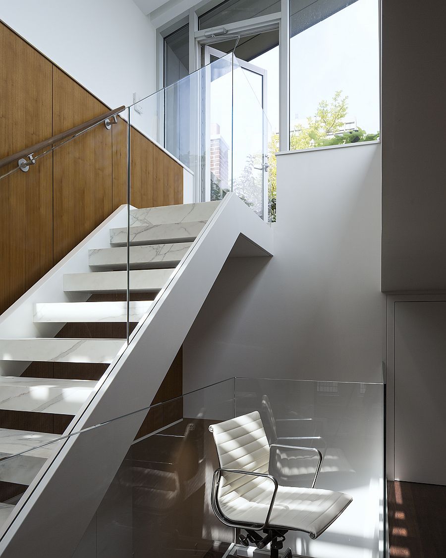 Open glass and marble stairs connect the various levels of the new and improved triplex