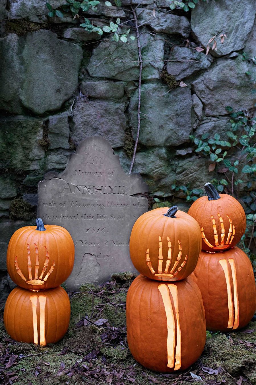 Skeleton hands carved on pumpkins give the yard a cool and spooky look