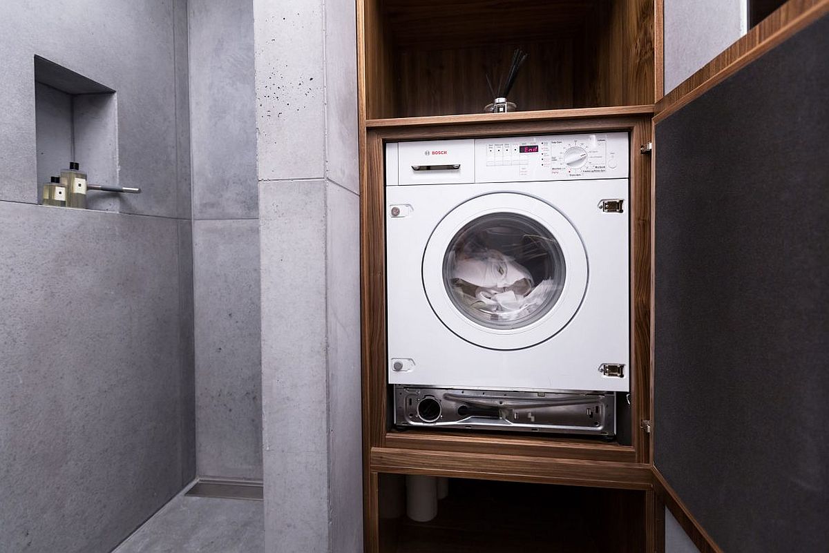 Space-conscious bathroom design that also holds the washing machine in a custom cabinet