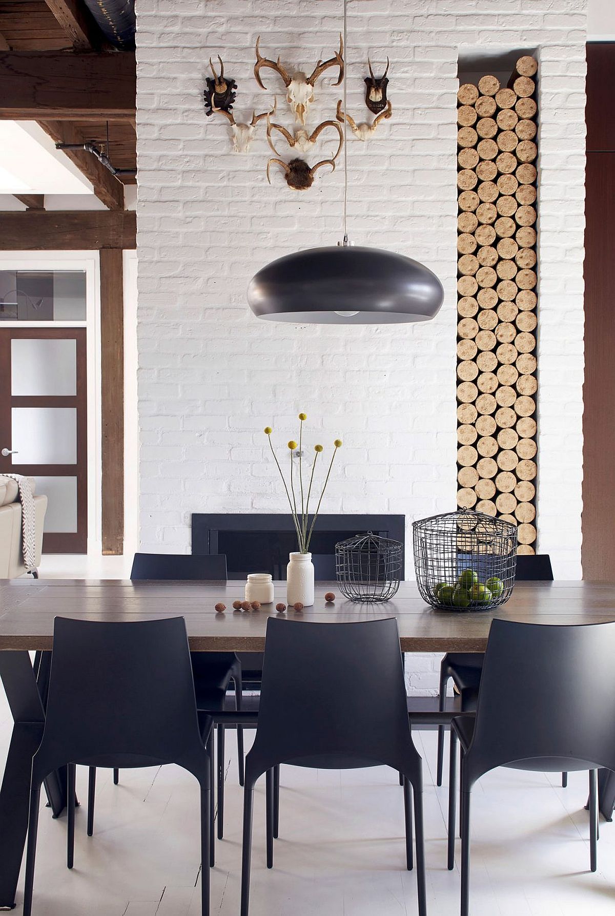 Stacked firewood adds textural beauty to the smart dining room