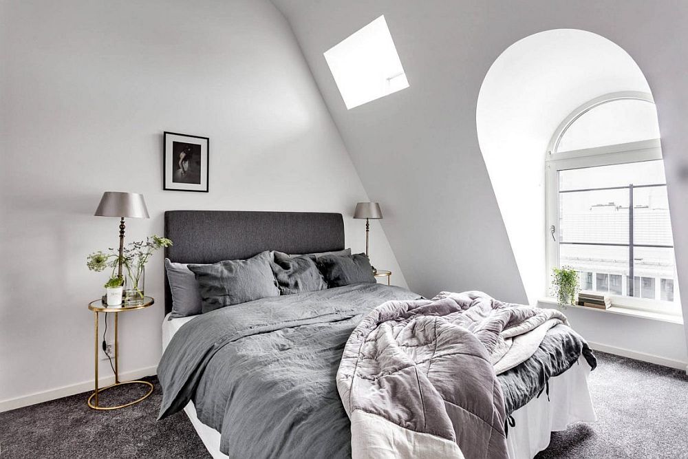 Tiny white bedroom with gray bed and large windows