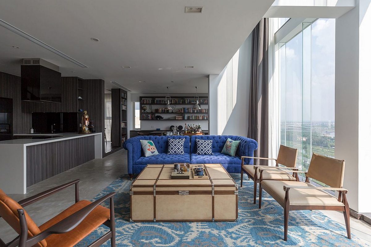 View of the living area, kitchen and dining room at modern green penthouse