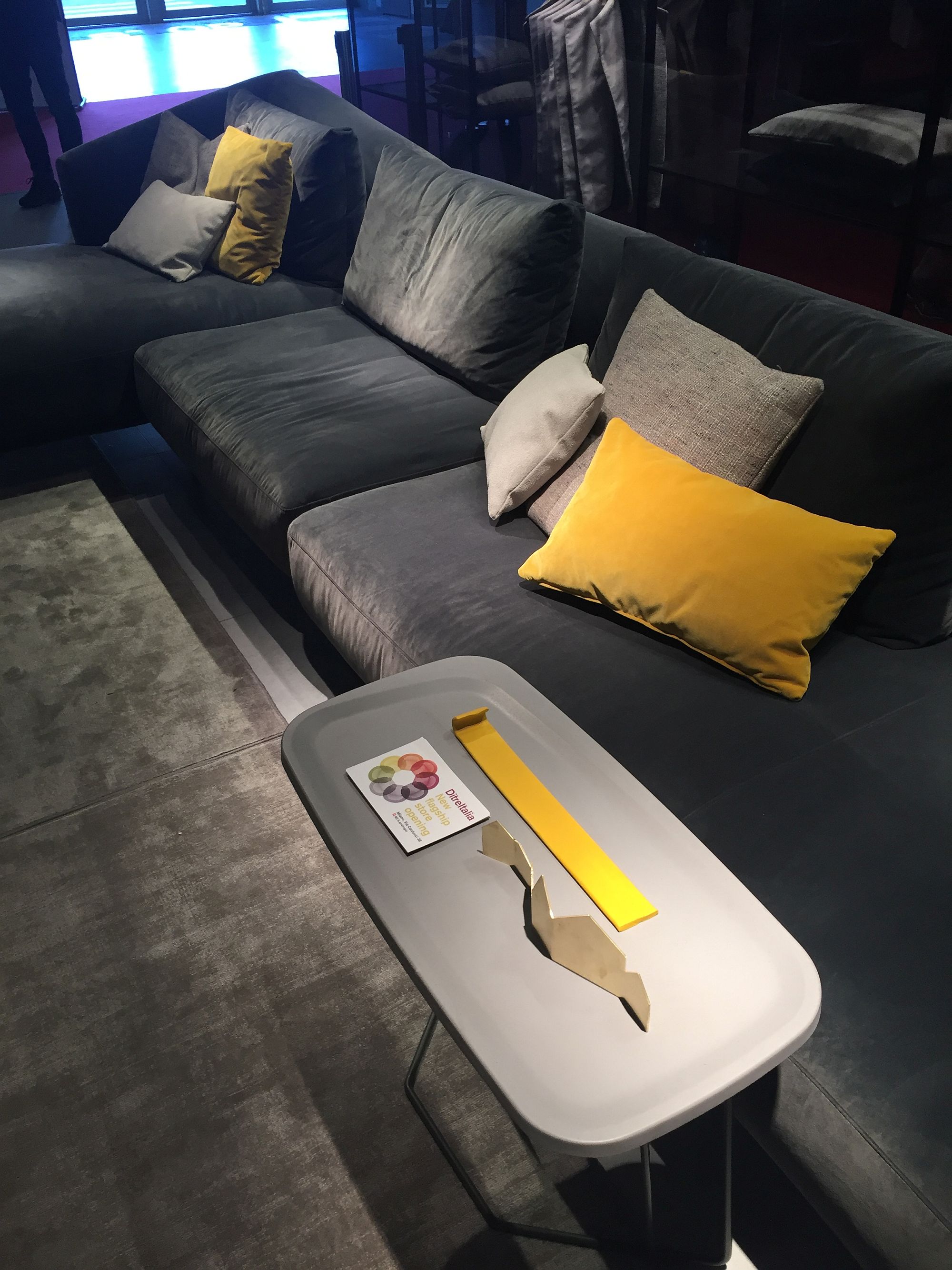 A dash of yellow using accent pillows brings color to the gray living room couch