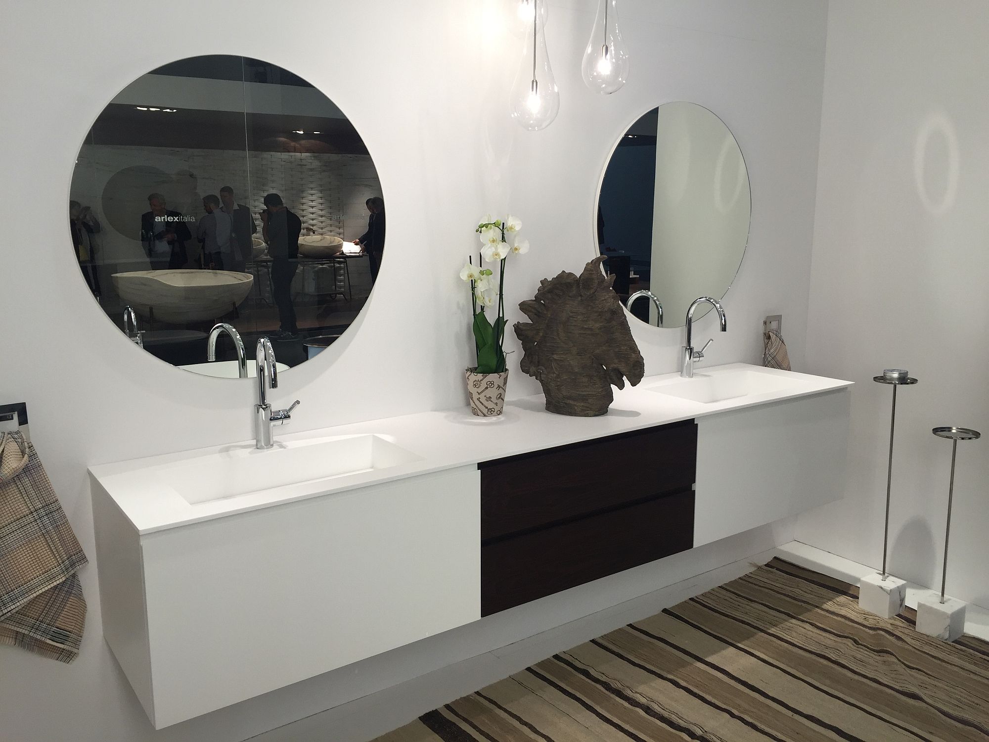 Contemporary bathroom vanity in white with a small vase and flowers that bring color to the setting