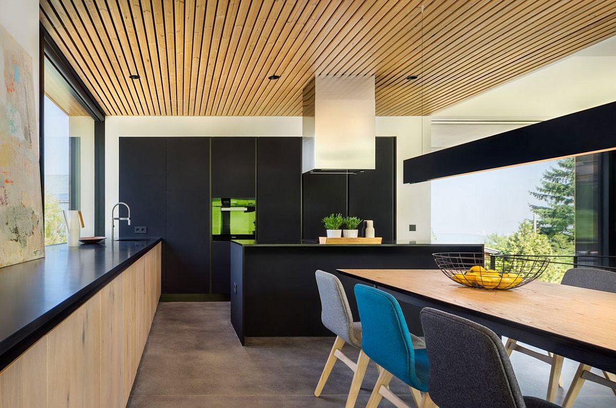 Contemporary kitchen in black and wood along with smart dining