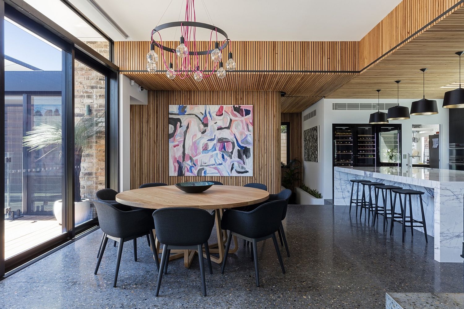 Dining room and kitchen with sliding glass doors and weatherboard backdrop