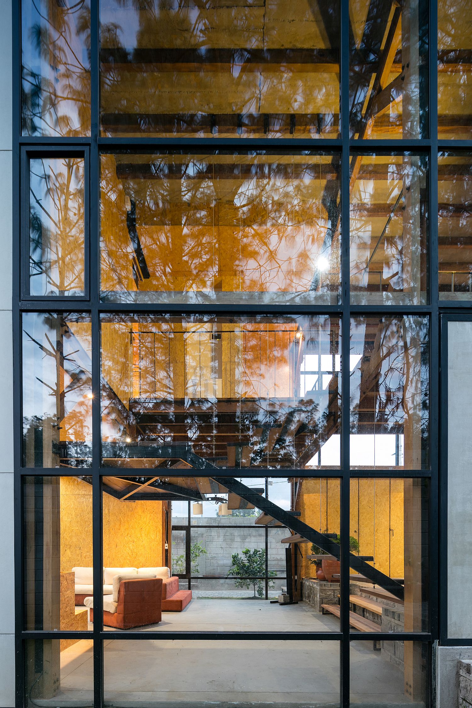 Large glass windows with metallic frame bring the outdoors inside