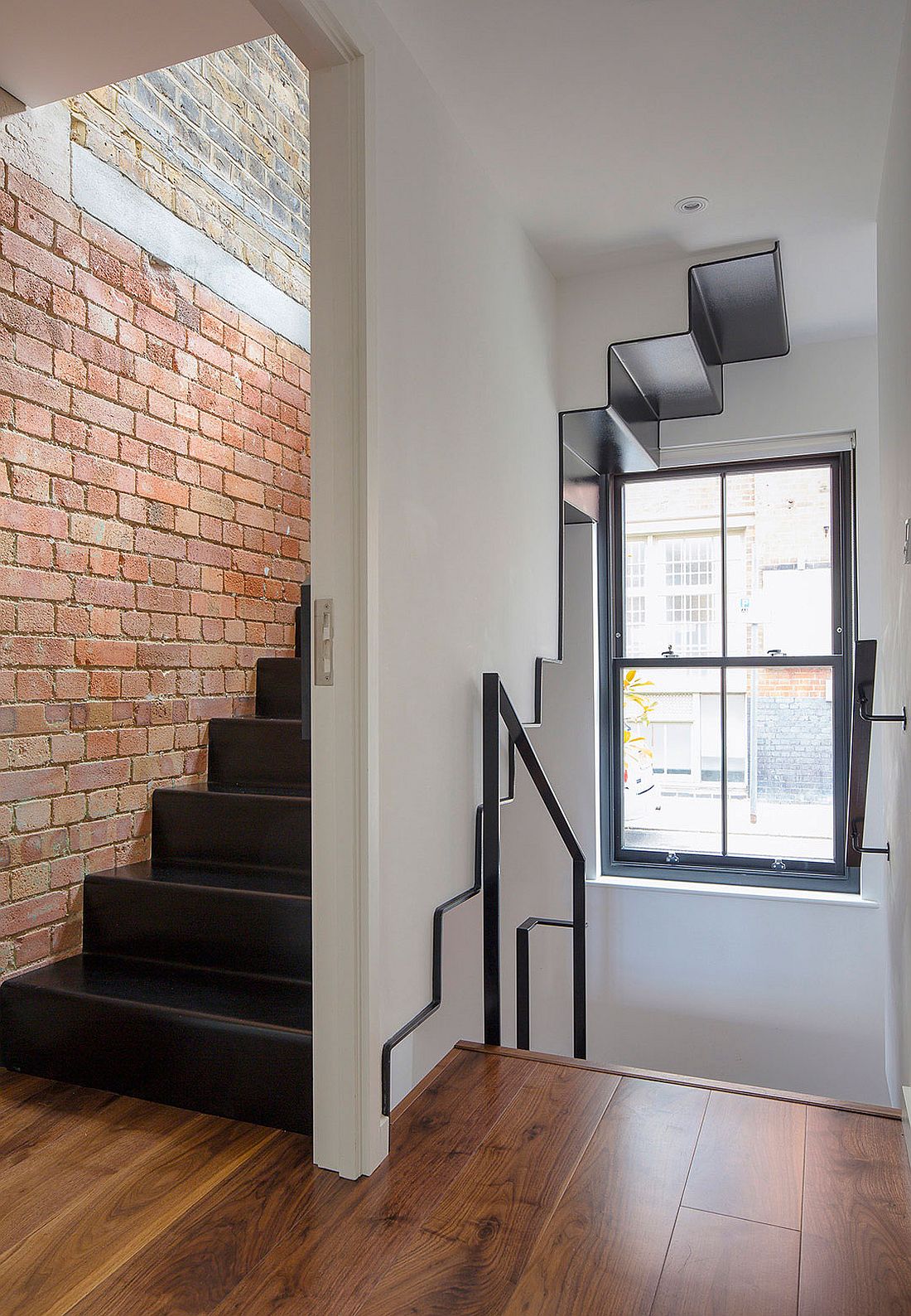 Metallic staircase leads to the master suite on the top level