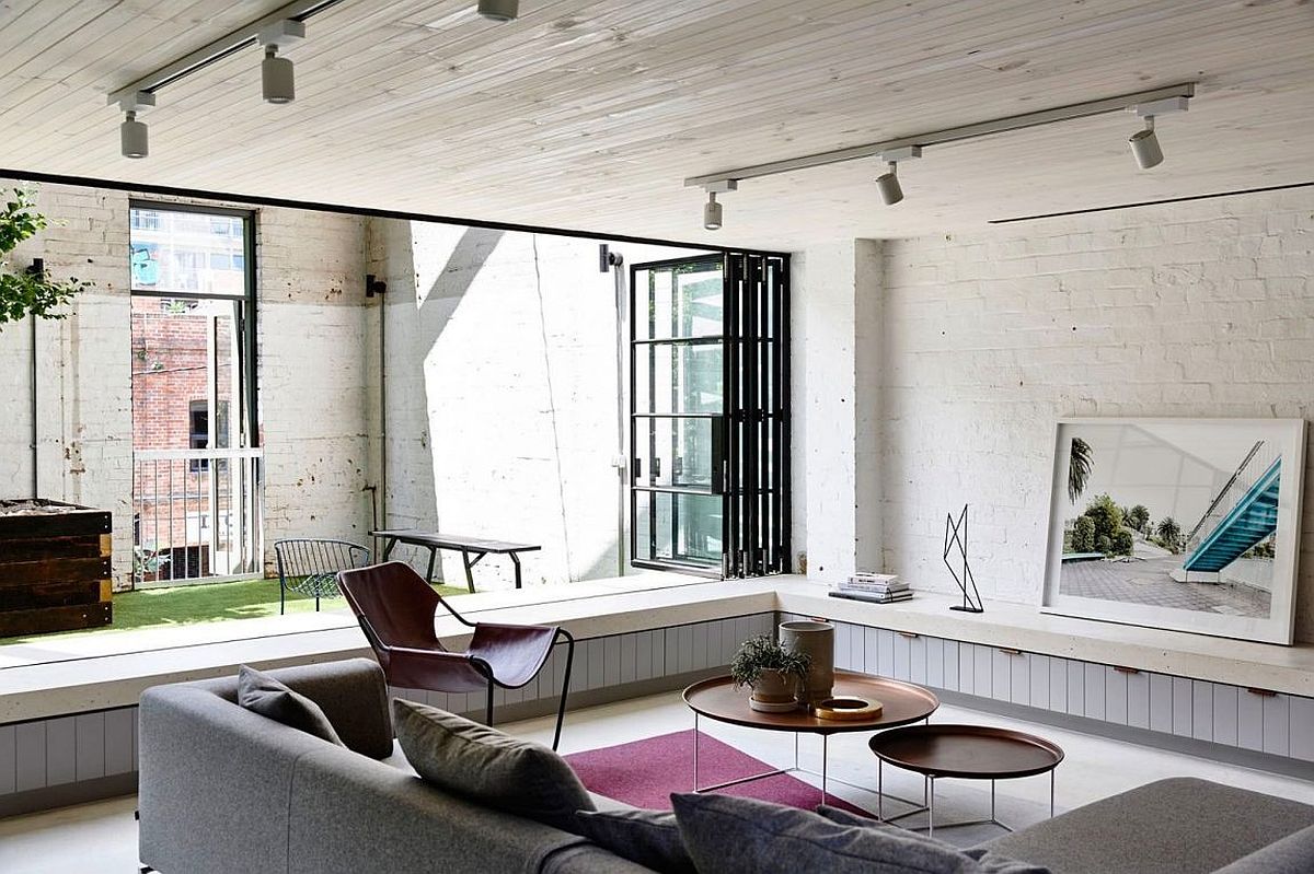 Modest living room connected with the yard and the view outside using folding glass doors