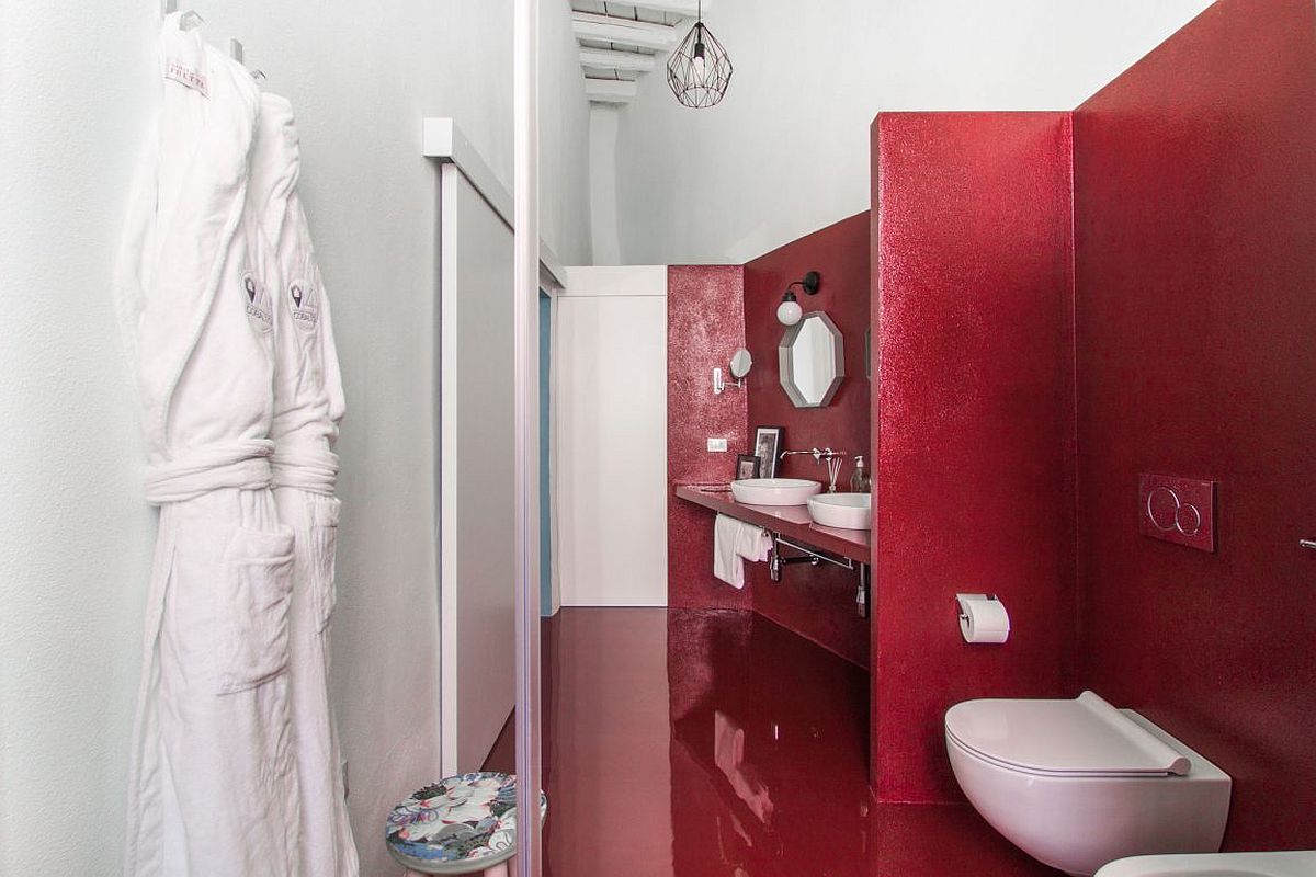 Red floor and walls in the bathroom present contrasting textures