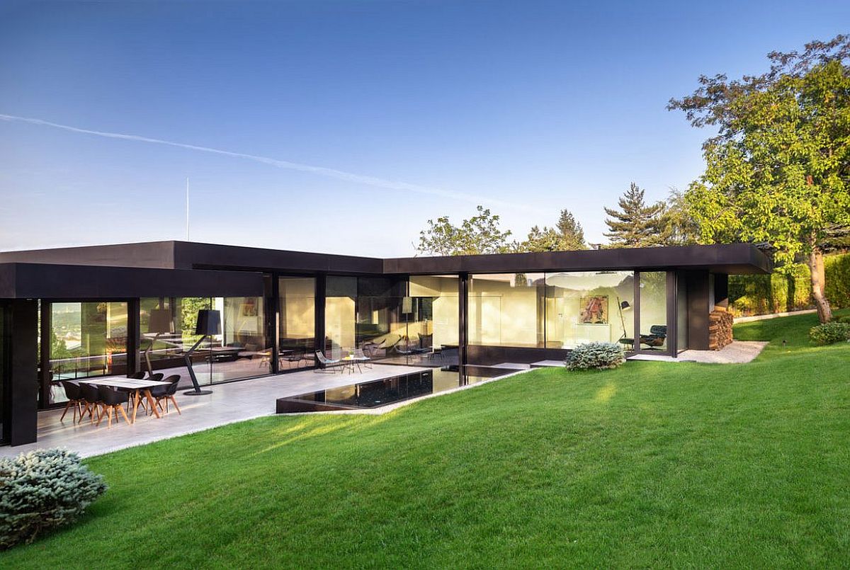 Series of glass walls and doors connect the lower level with the sloped garden outside