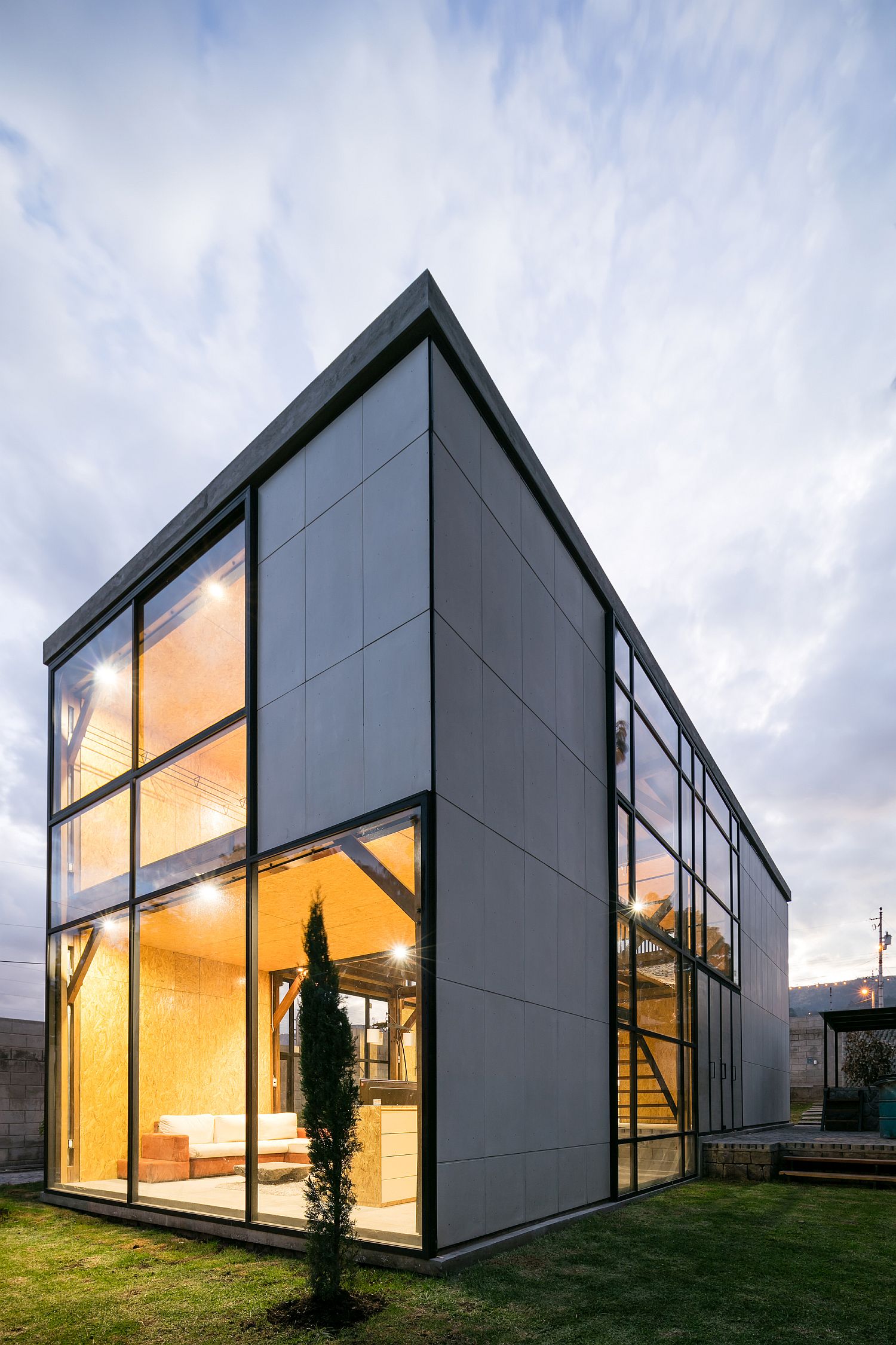 Simple cement panels with socket joints and glass windows shape the multi-generational home in Quito