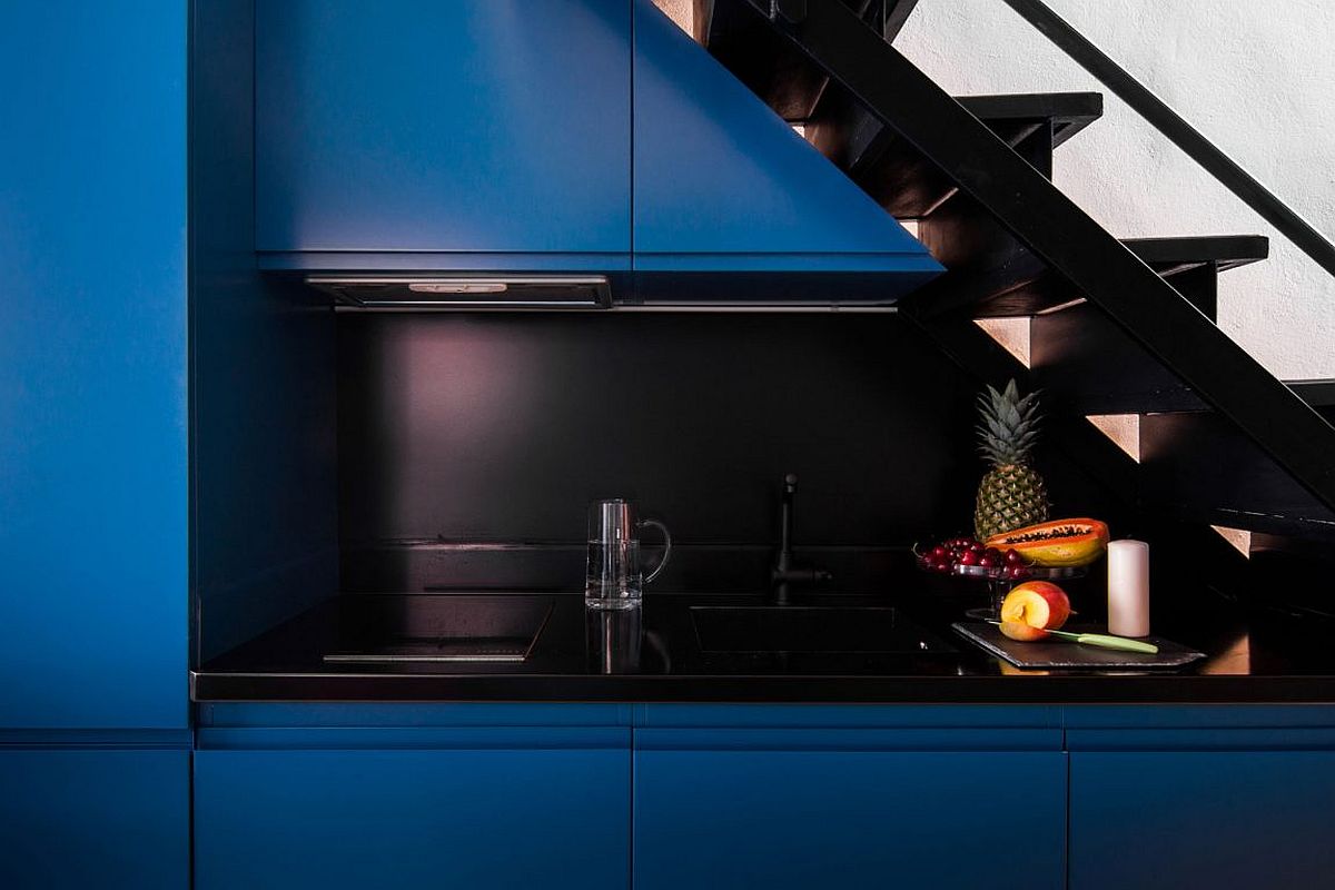 Smart modern kitchen station with cabinets in blue and a black countertop