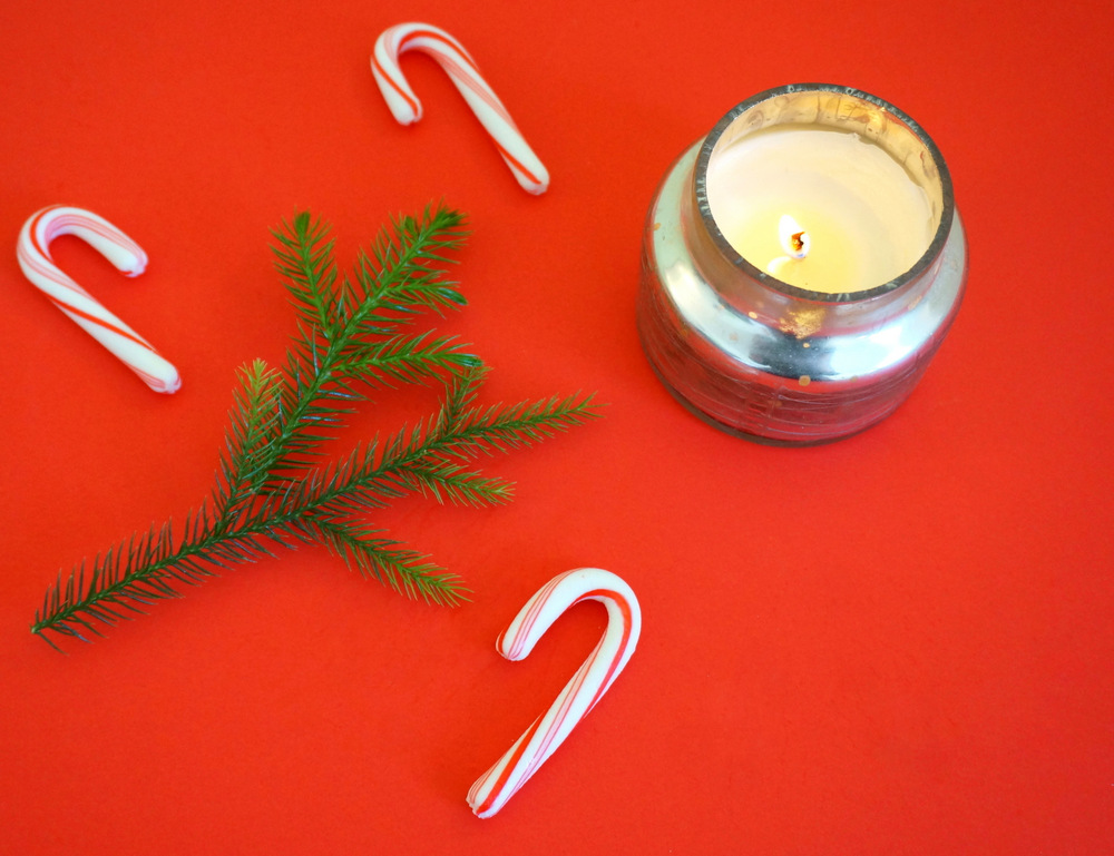 Candy canes, greenery and a flickering candle create holiday cheer