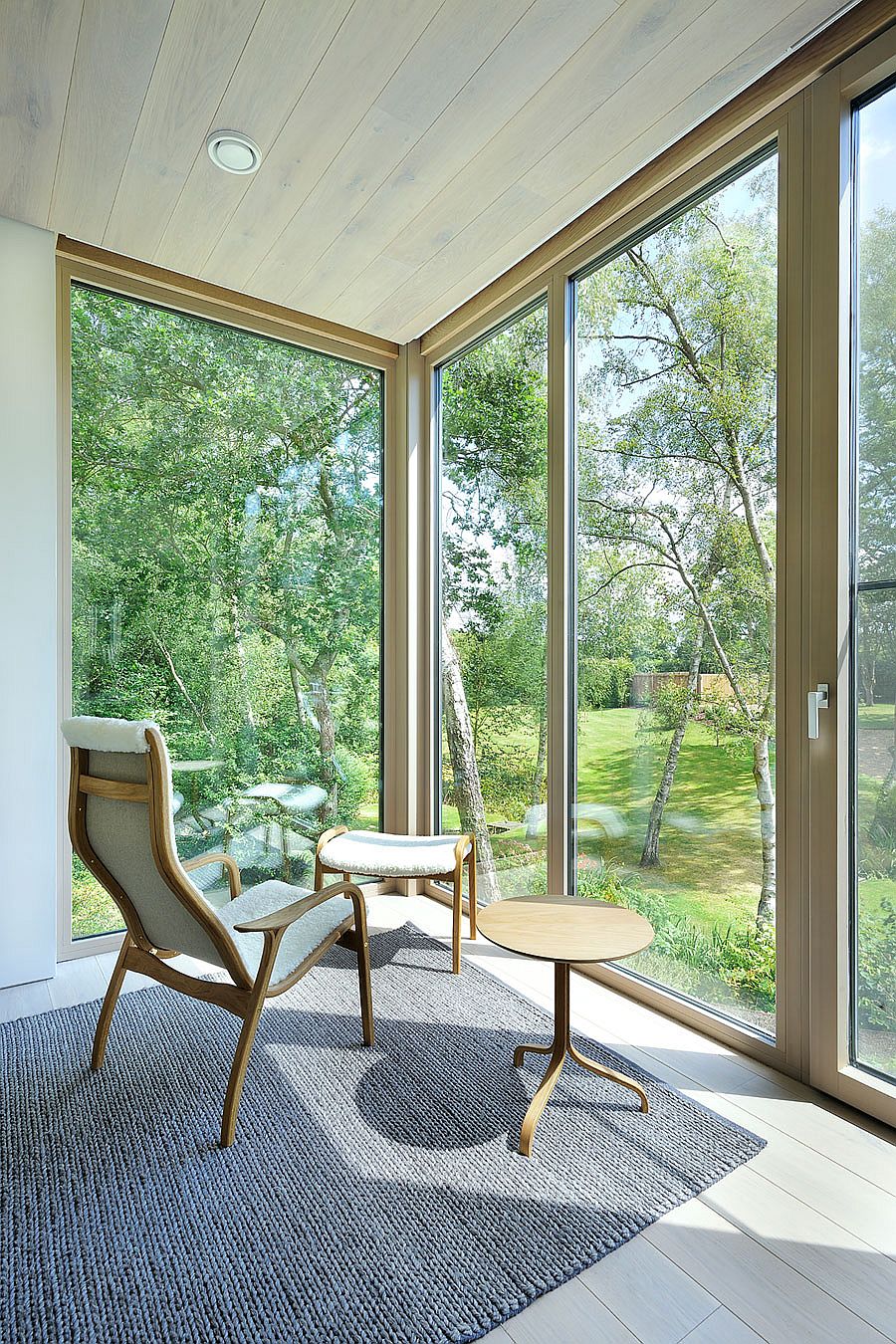 Corner glass walls open up the interior to the forest outside