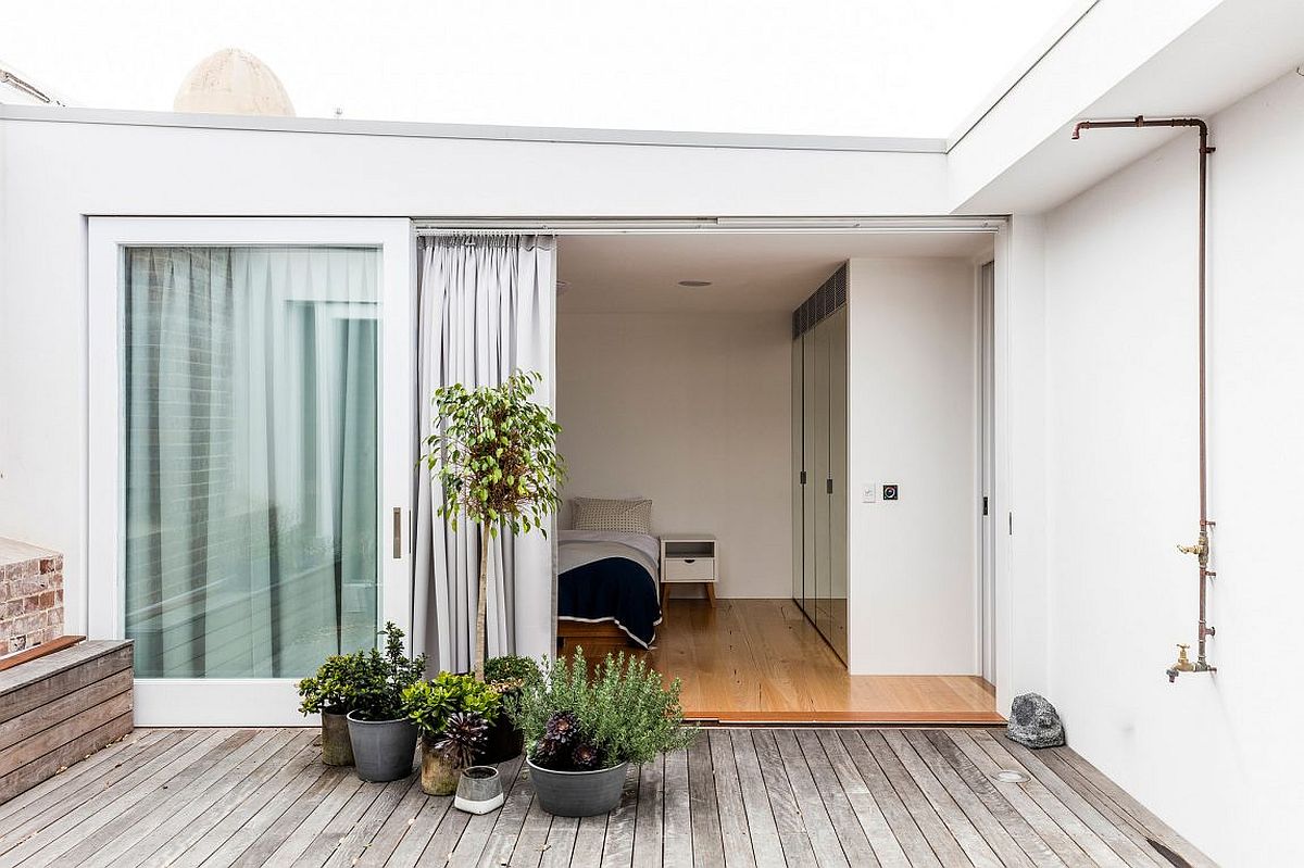 Elegant bedroom connected with the wooden deck of the apartment