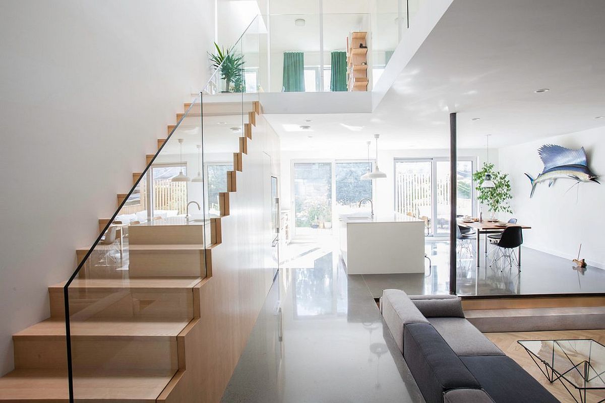 Gorgeous wooden staircase with glass railing also offers plenty of storage space