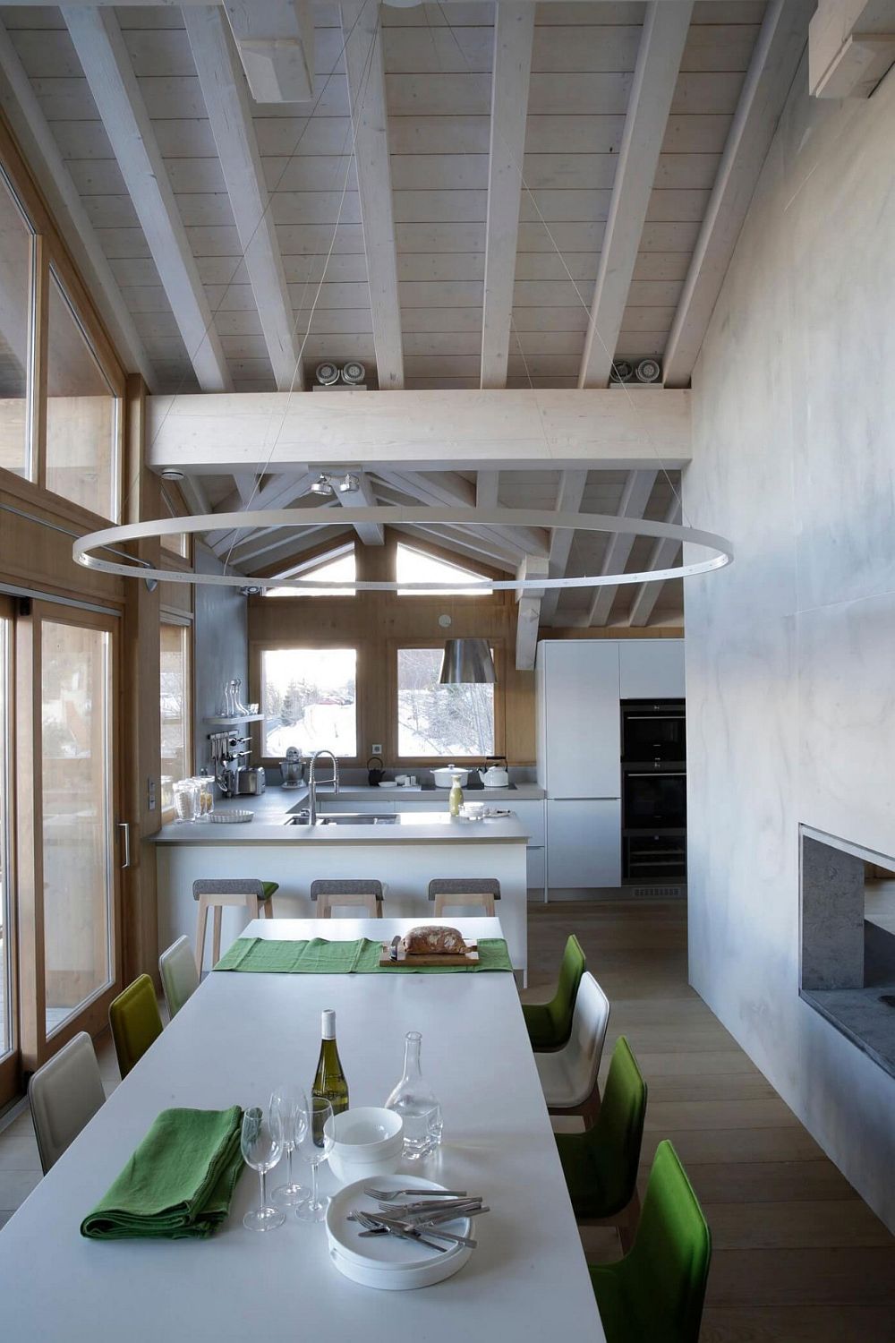 Green chairs add color to the neutral dining room