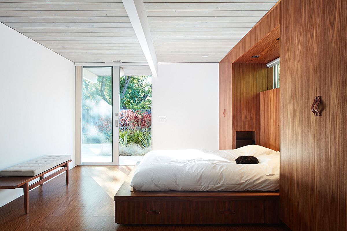 Head of the bed tucked within the wooden wardrobes