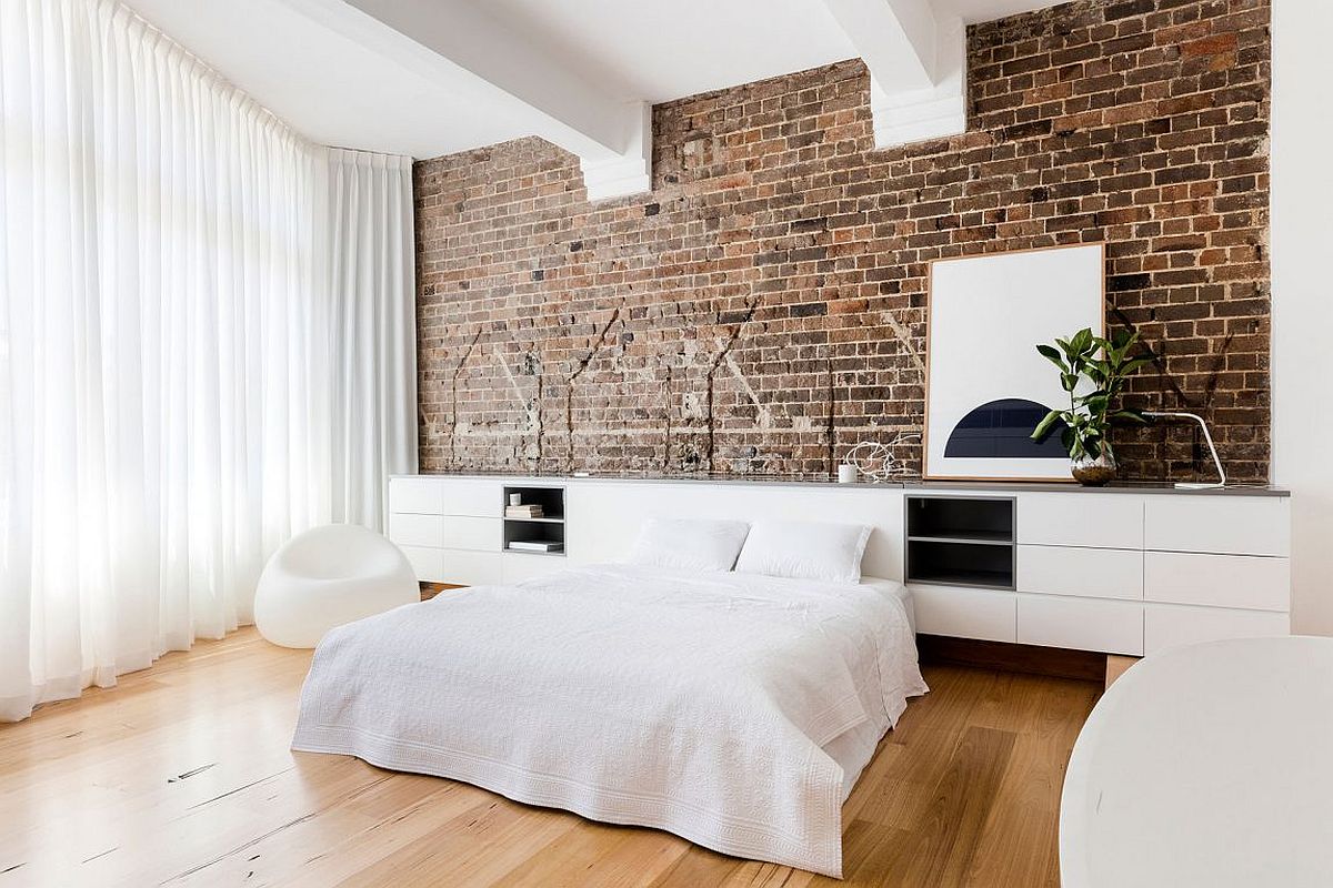 Modern bedroom in white with exposed brick wall