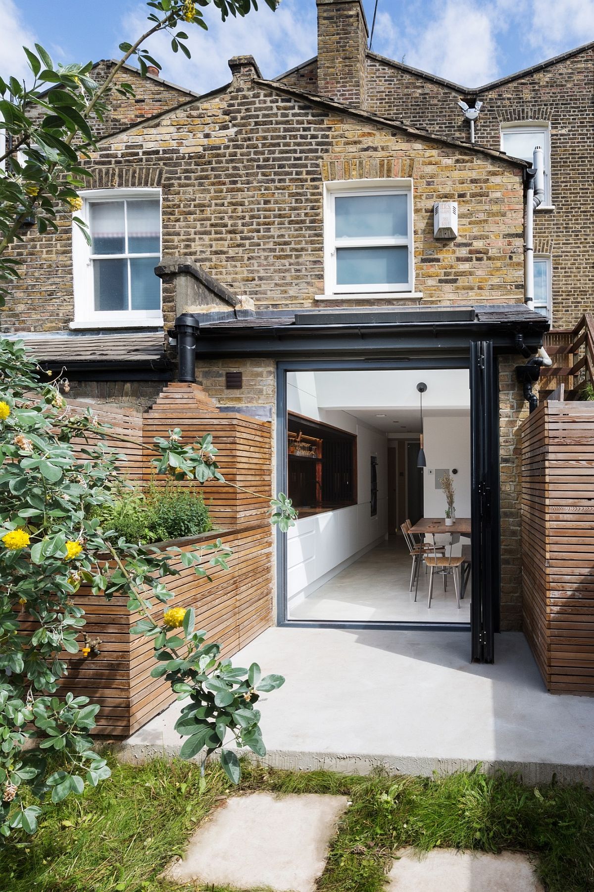 New kitchen, dining and sunken bath of the London home extend into the garden outside