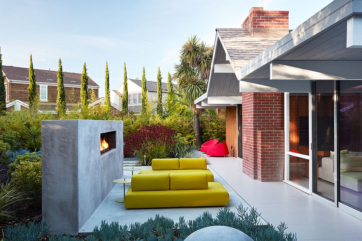 Outdoor hangout with bright yellow seating and contemporary fireplace