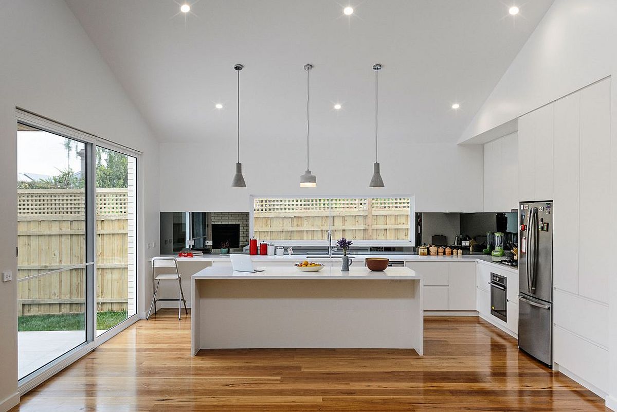 Contemporary kitchen in white with a dark backsplash