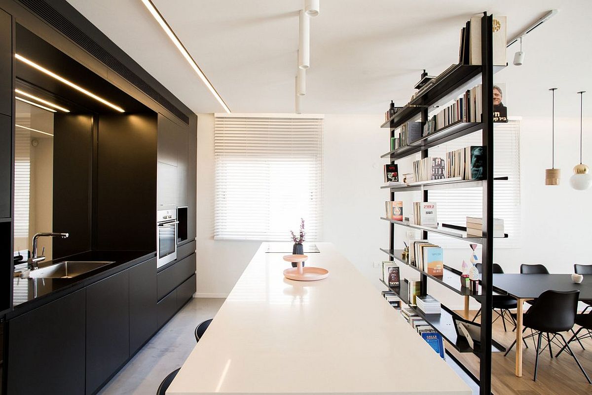 Dark cabinets and bookshelf flank the modern kitchen inside the penthouse