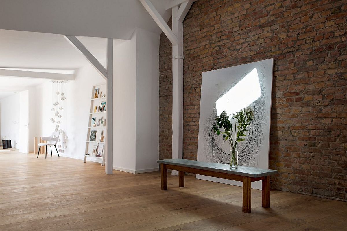 Elegantly placed art in front of the brick wall inside the penthouse apartment