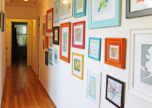 Hallway gallery with colorful frames on a white wall.