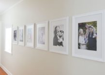 Hallway gallery with large white framed family pictures.
