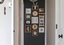 Hallway gallery with multiple framed pictures on a dark wall.
