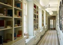 Long hallway with multiple bookshelves and a striped rug.