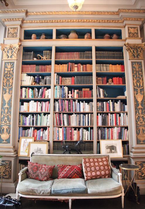 A spacious bookcase filled with numerous books of various sizes and colors.
