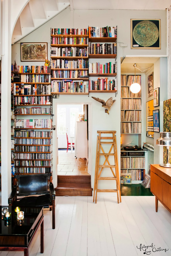 A cozy living room with bookshelves and a wooden ladder. 