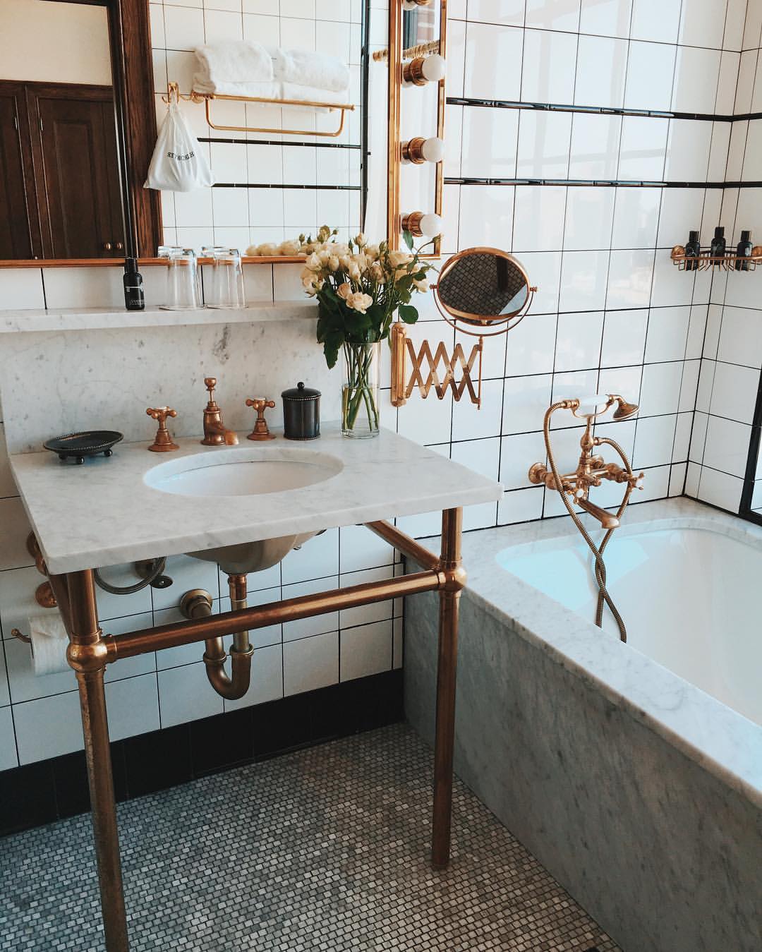 A luxurious bathroom featuring a marble sink and many copper fixtures.