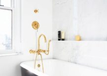 White and black bathroom finished with marble and gold fixtures.